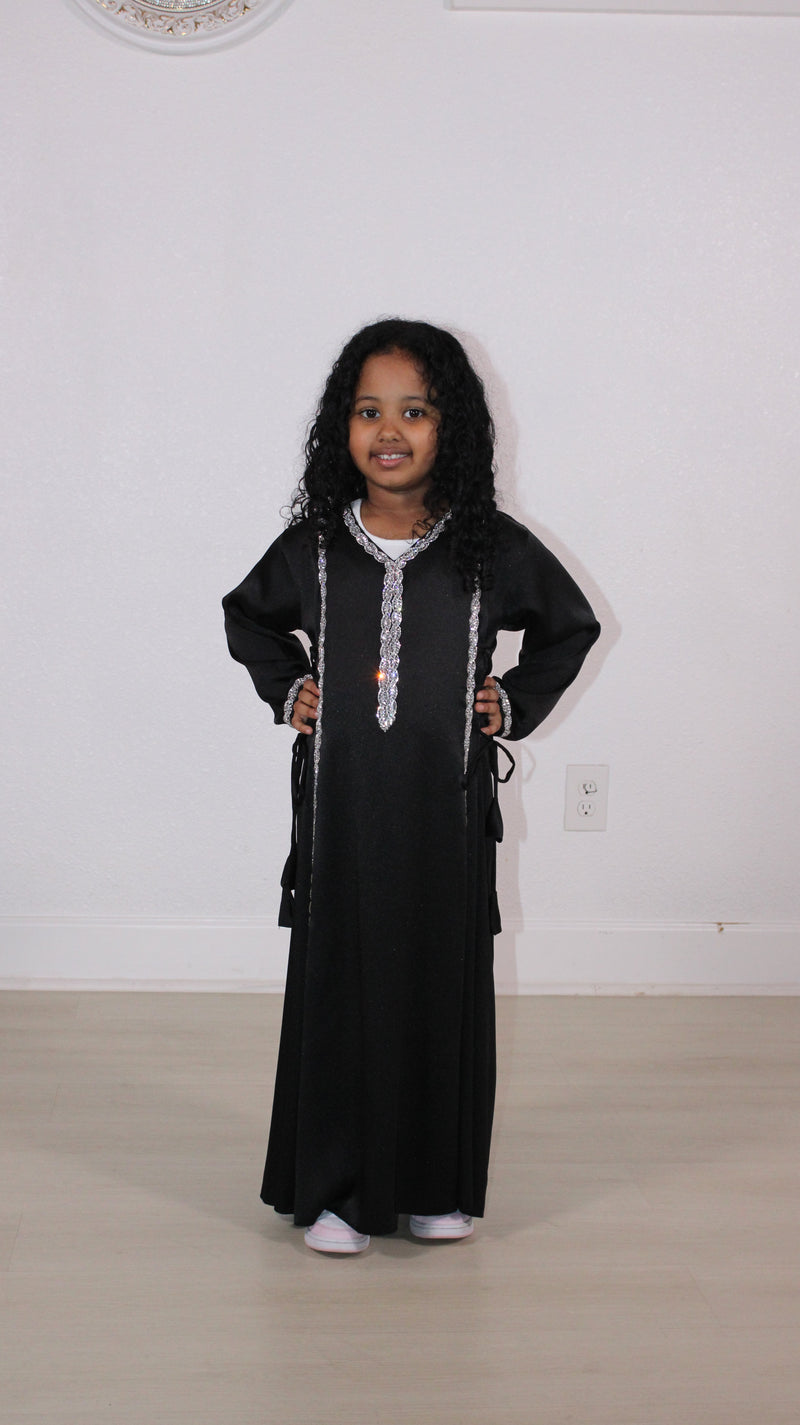 Girl in a black kids abaya with silver trim