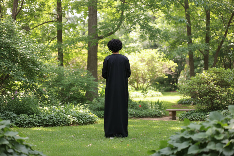 Man in a black thobe in a garden